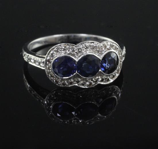 A modern platinum, sapphire and diamond triple cluster ring, size M.